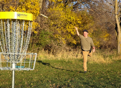Man playing disc golf in Spencer Park
